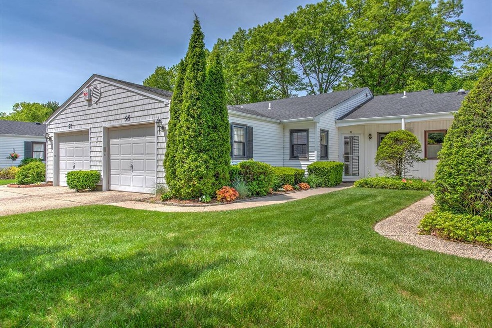 Ranch-style house with a front yard, a shingled roof, and concrete driveway