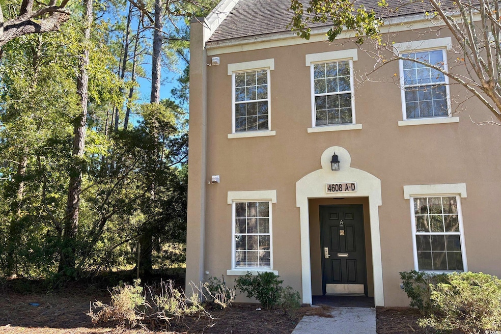 View of front facade with a shingled roof and stucco siding