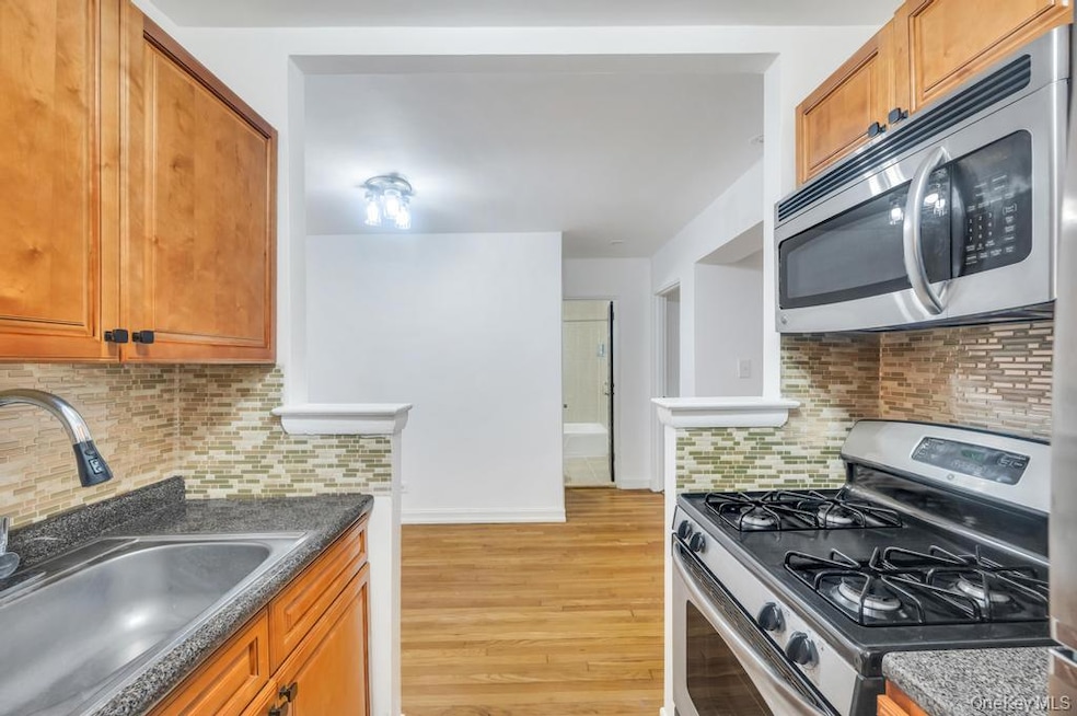 Kitchen with appliances with stainless steel finishes, decorative backsplash, and brown cabinets