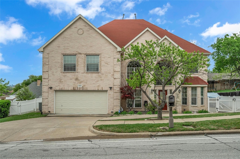 View of front facade with a gate, driveway, fence,