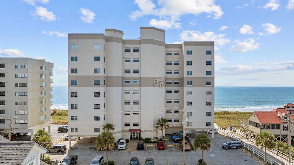 View of apartment building / complex with view of water and beach