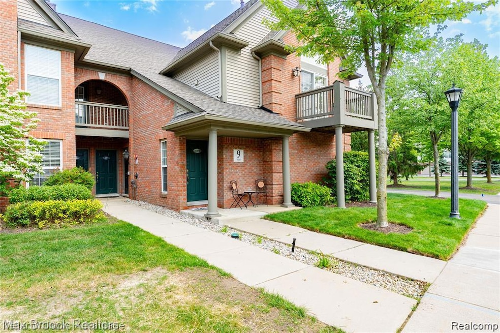 Traditional-style home with a balcony, a front yard, and a shingled roof