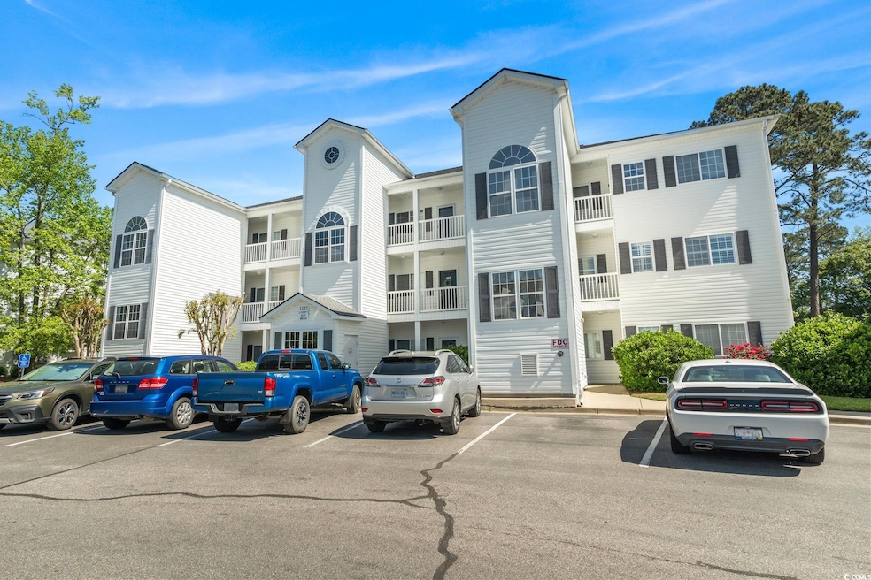 View of building exterior with uncovered parking