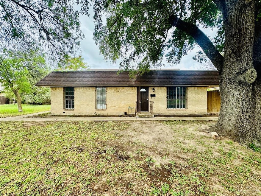 Ranch-style home featuring brick siding, mansard roof, roof with shingles, and a front yard