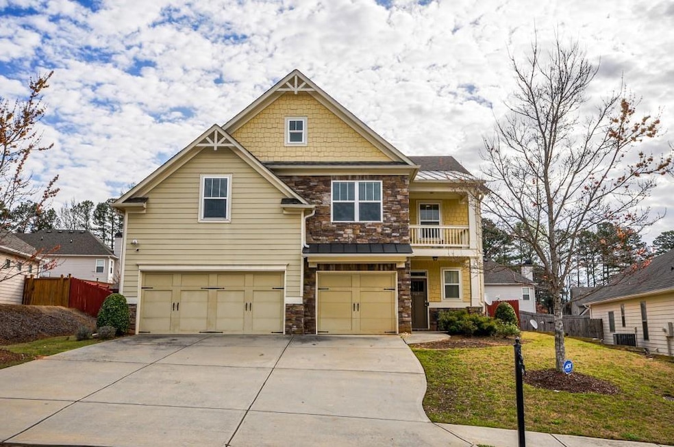 Craftsman inspired home with an attached garage, stone siding, driveway, and a standing seam roof