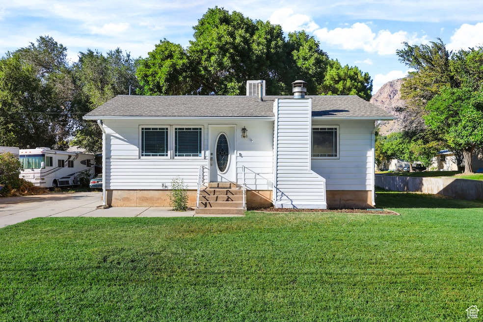 View of front of house featuring a chimney and a shingled roof