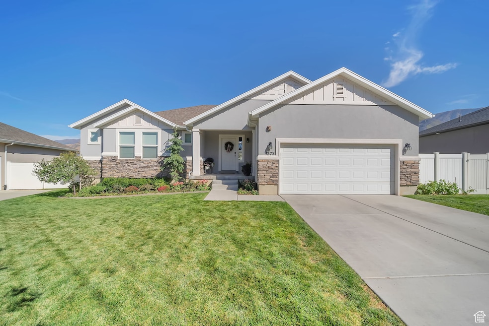 View of front of home with stone siding, board and batten siding, and concrete driveway
