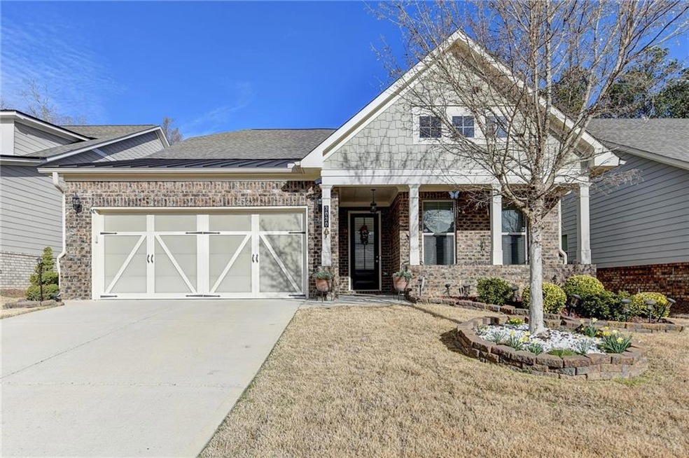 View of front of home with brick siding, driveway, and a garage