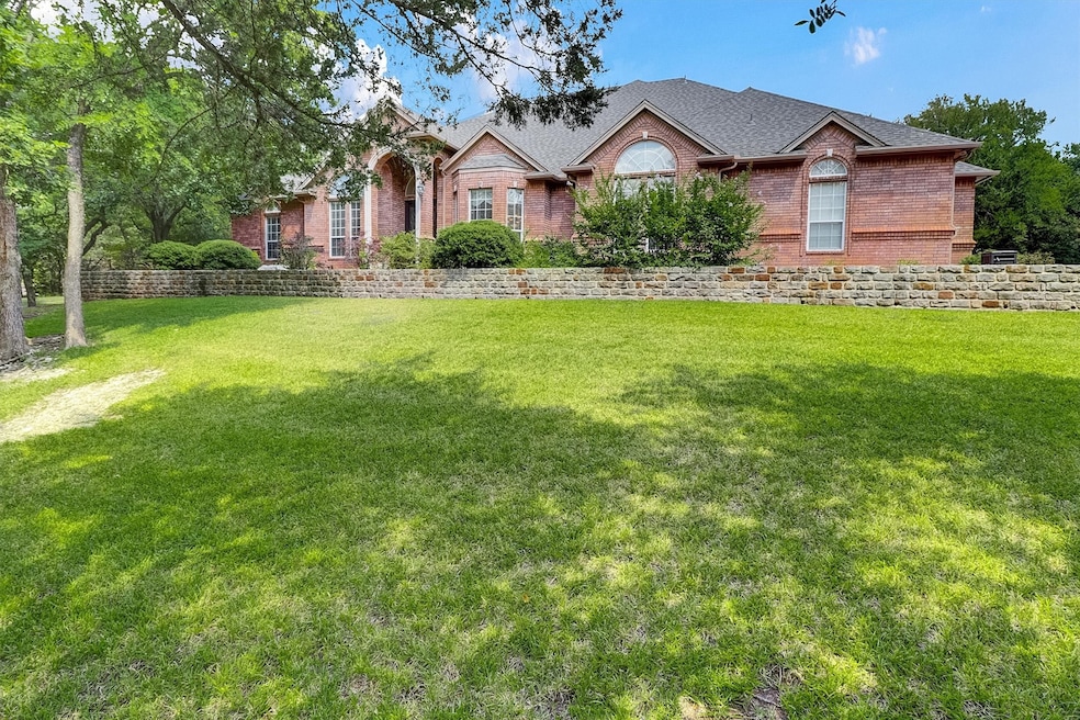 View of front of house with brick siding, a front yard, and a shingled roof