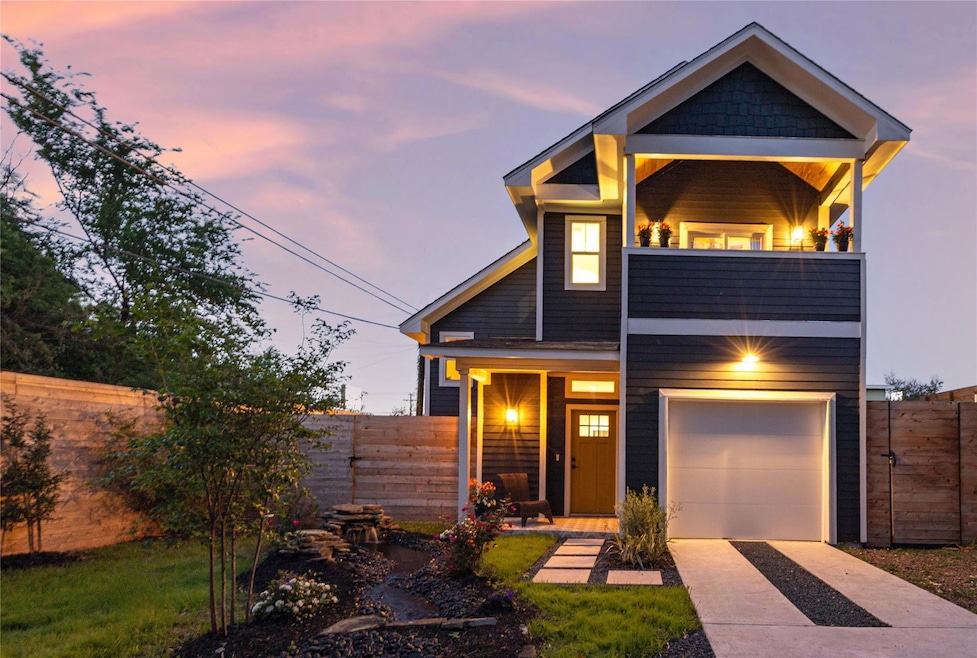 View of front of home with driveway, a balcony, a