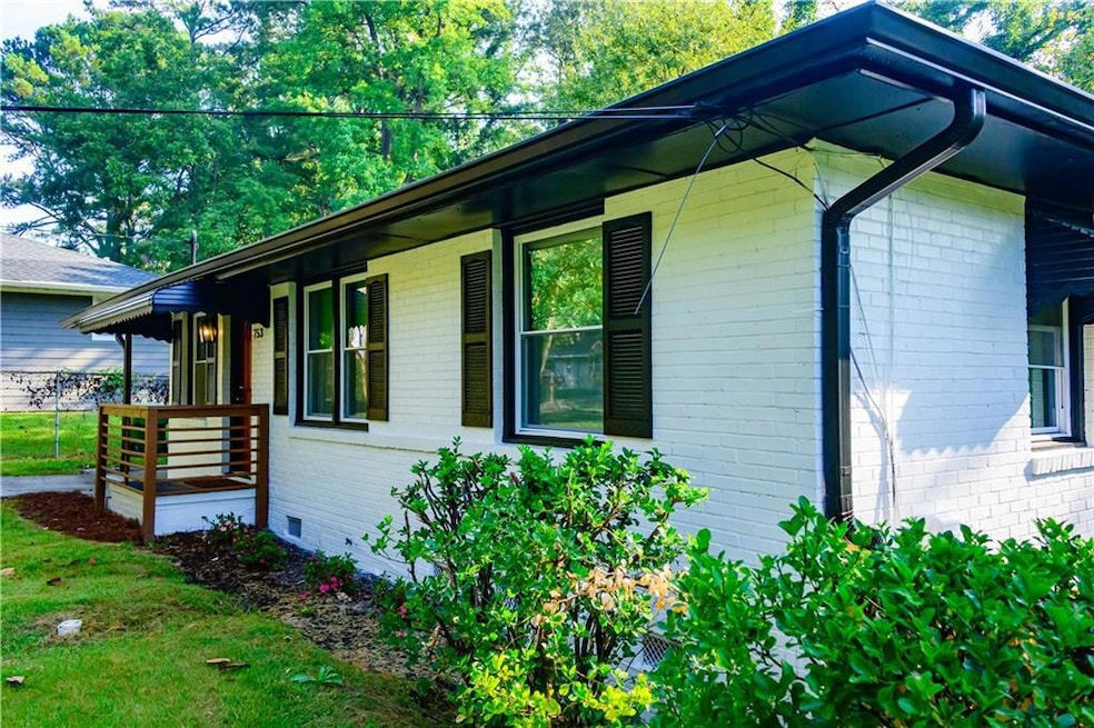 View of side of property featuring brick siding, a porch, crawl space, and a lawn