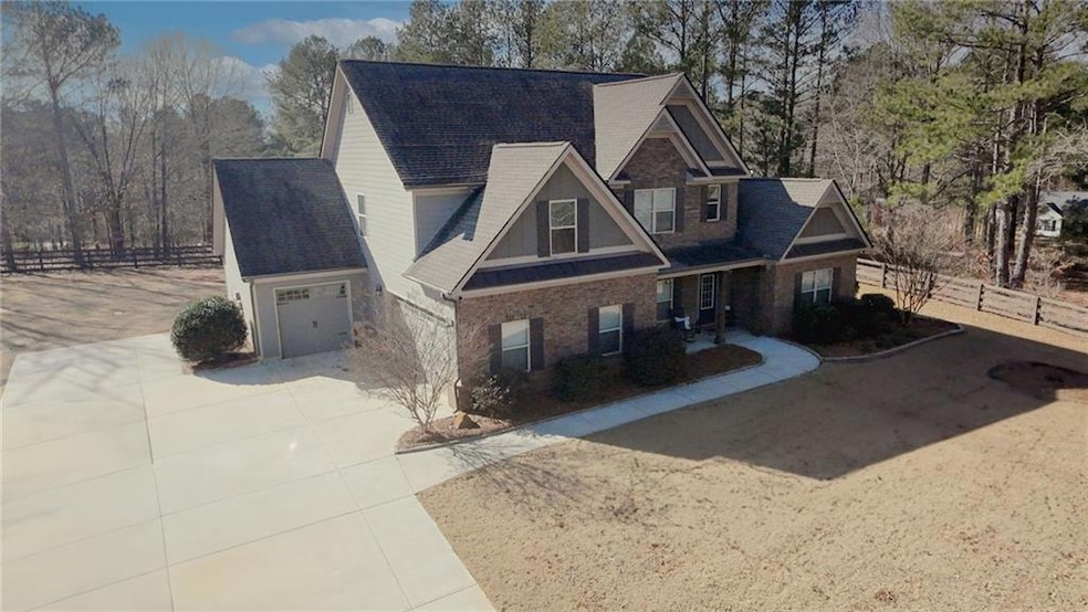 View of front of house with a garage, fence, brick