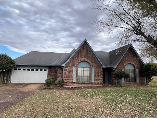 View of front of home with a front yard and a gara