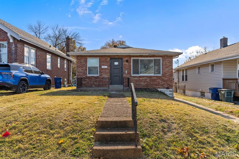 Bungalow-style home featuring brick siding and a front yard