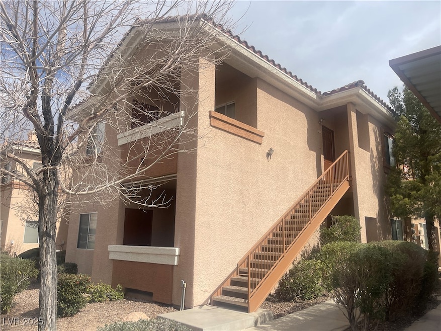 View of side of home with stucco siding, a tiled r