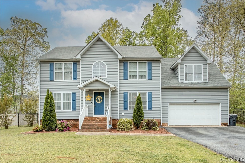 Colonial home featuring a front lawn and a garage
