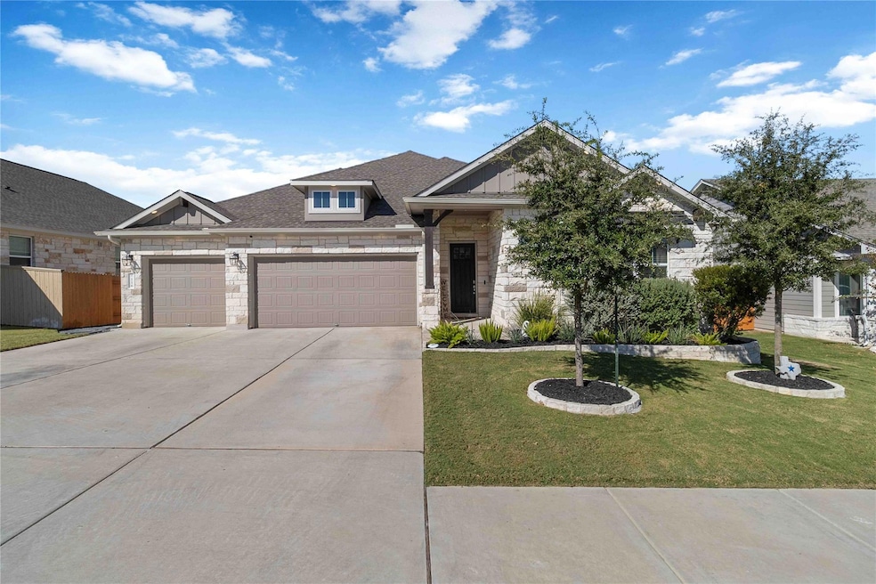 View of front of home featuring stone siding, roof with shingles, driveway, board and batten siding, and an attached garage
