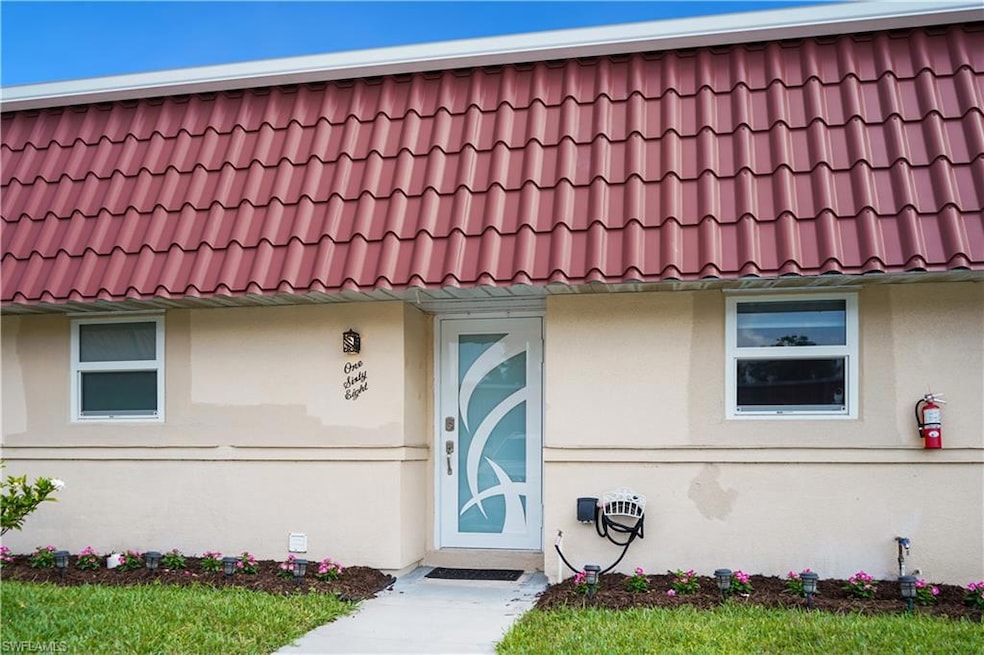 View of front facade featuring a tile roof and stu