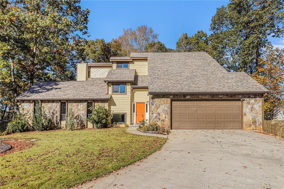 Mid-century modern home featuring stone siding, driveway, a chimney, and a front lawn