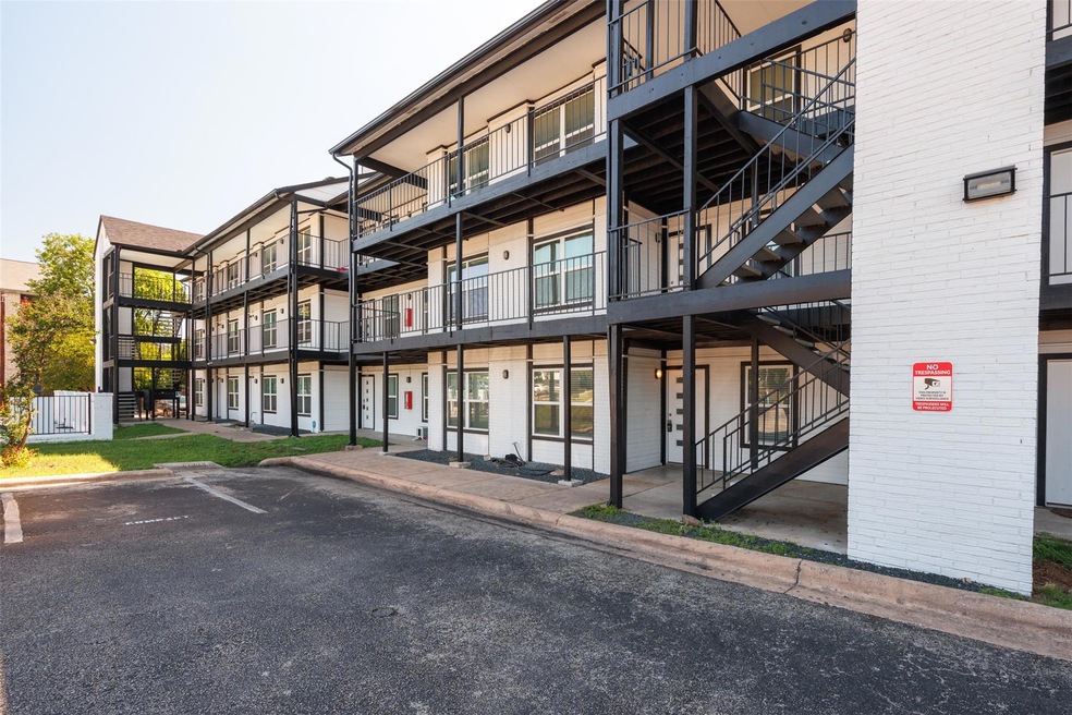 View of building exterior with uncovered parking 