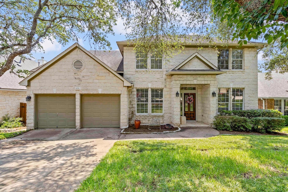 View of front of house featuring concrete driveway, stone siding, and a garage