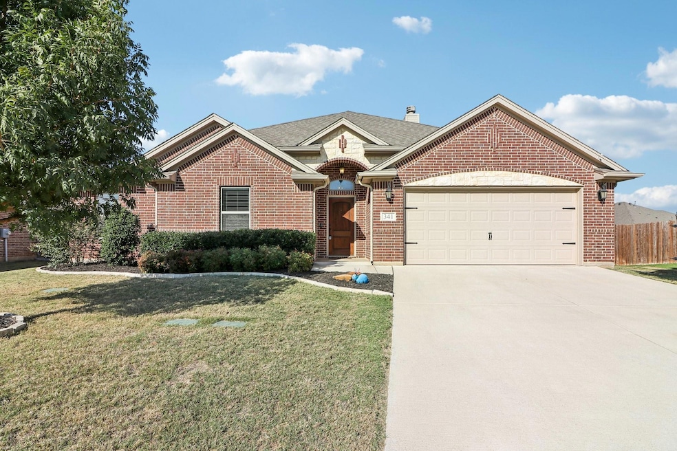 View of front of home with a garage and a front la