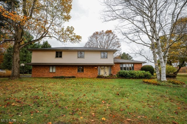 View of front of property featuring a front lawn and brick siding