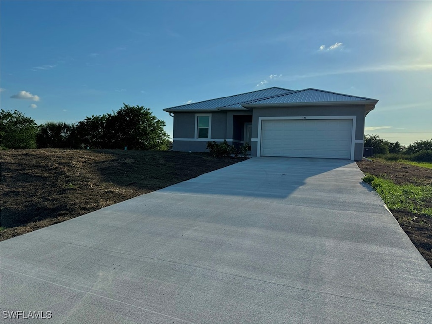 View of front of house with driveway, a garage, st