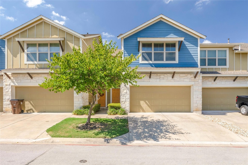 View of front facade with driveway, stone siding,