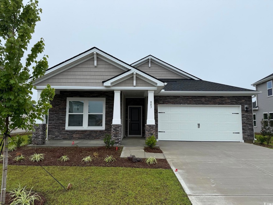 Craftsman inspired home featuring concrete driveway, an attached garage, a front yard, stone siding, and covered porch