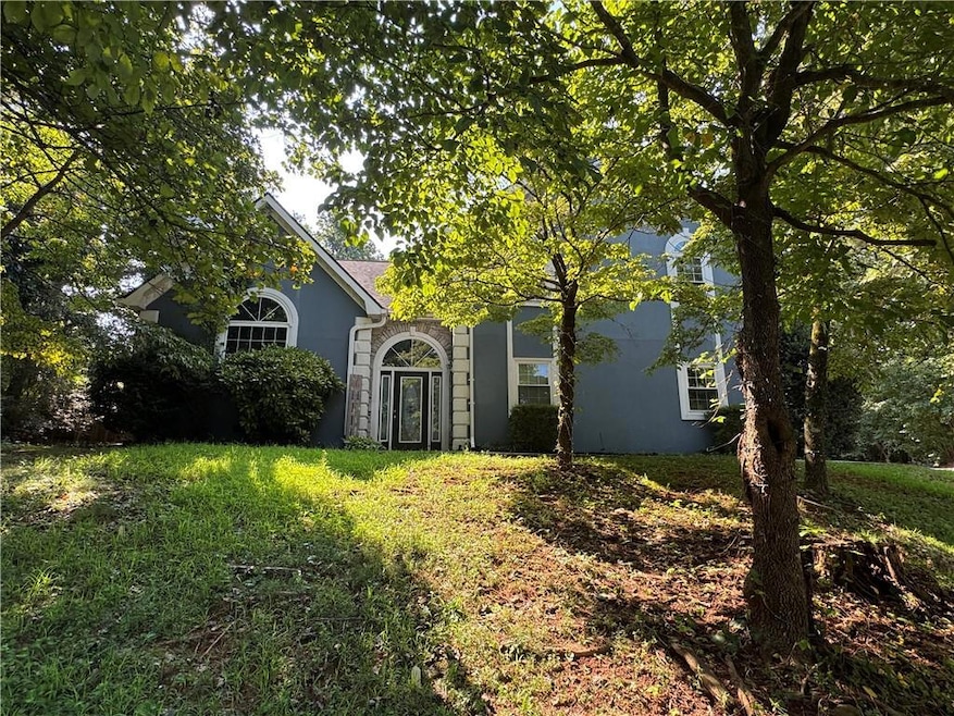 Obstructed view of property with stucco siding and a front yard