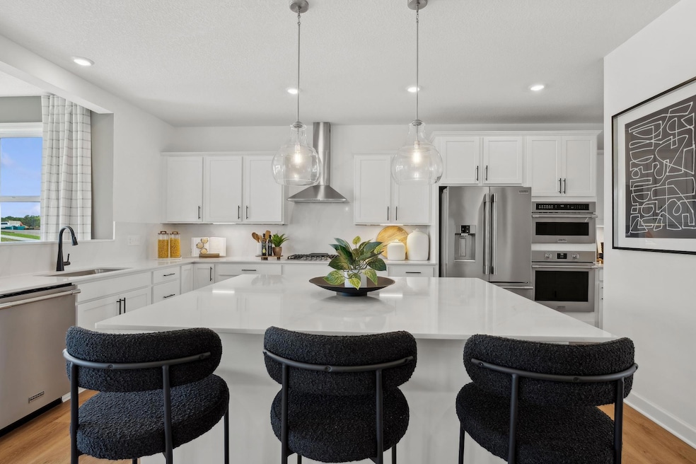 (Photo of a decorated model, actual finishes will vary) The spacious kitchen naturally serves as the heart of this home, complete with a generous center island, brand-new appliances and a walk-in pantry.