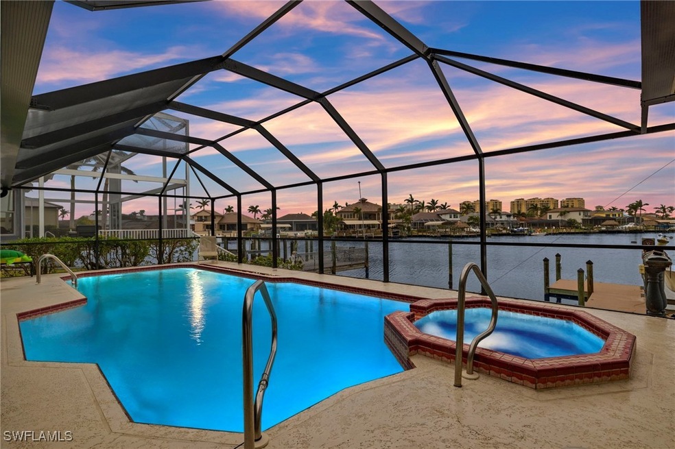 Pool at dusk featuring an in ground hot tub, a wat