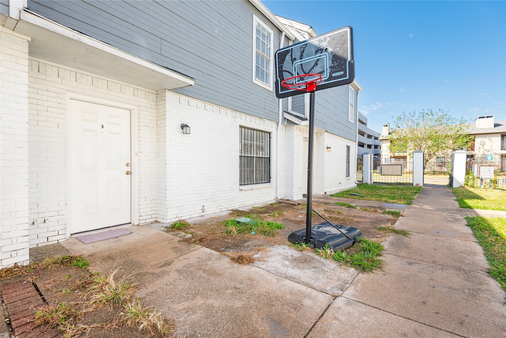 Property entrance with a gate and brick siding
