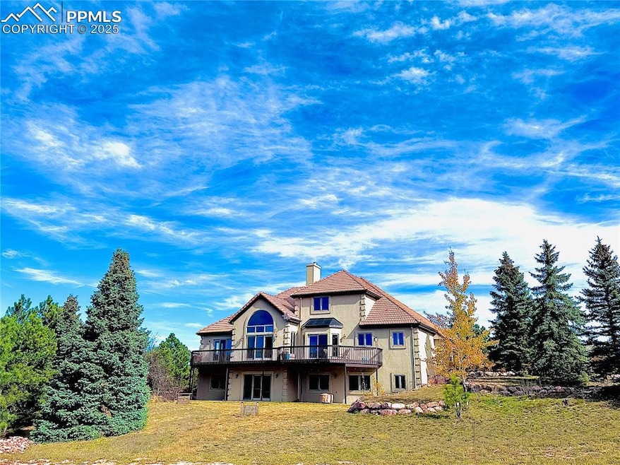 Rear view of house featuring a yard, a chimney, NEWstucco siding, and a deck