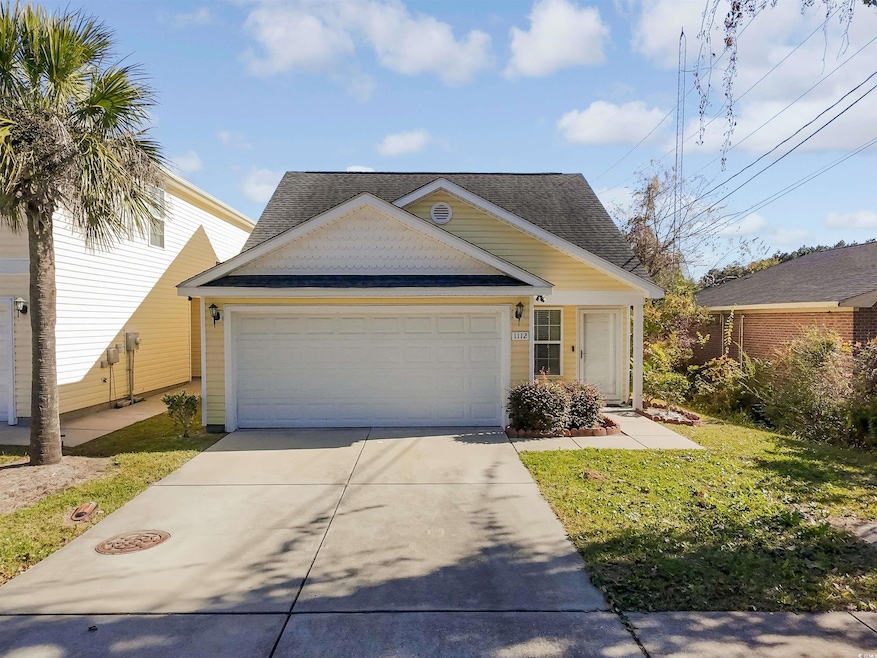 View of front of property with concrete driveway and an attached garage
