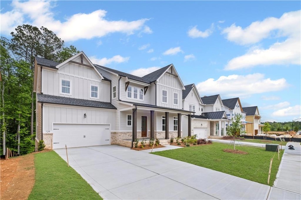 Modern inspired farmhouse with board and batten siding, driveway, covered porch, and a front yard