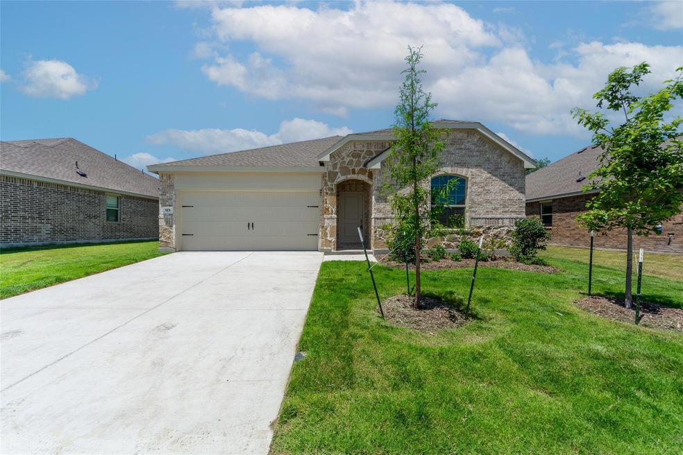 View of front of property with a front yard and a garage