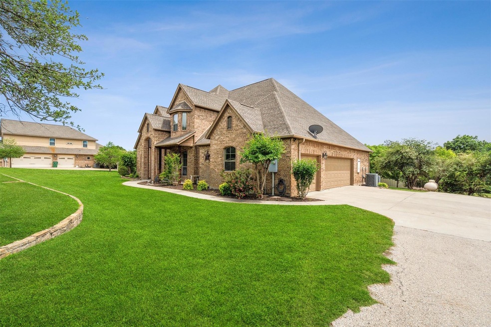 View of front of house with central AC, a front yard, and a garage