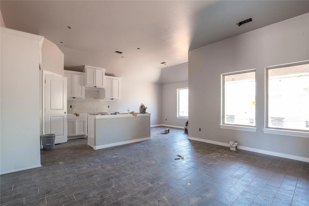 Kitchen with backsplash, dark tile flooring, and w