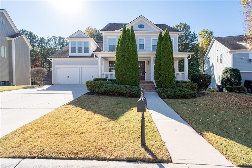 View of front of home with covered porch, driveway, and a front yard