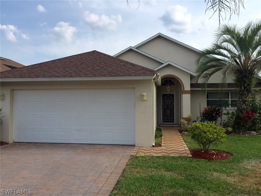 Front of the house. Mature landscaping. Paved driveway.