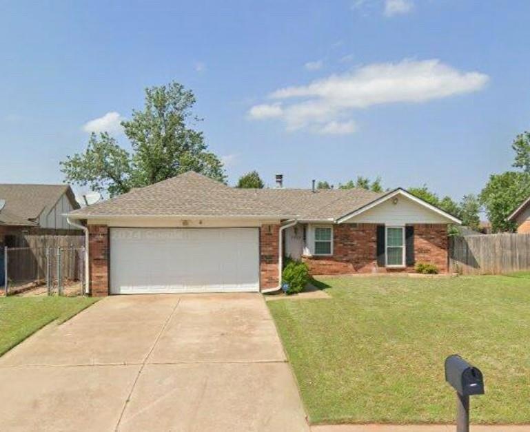 Ranch-style house with a garage and a front lawn