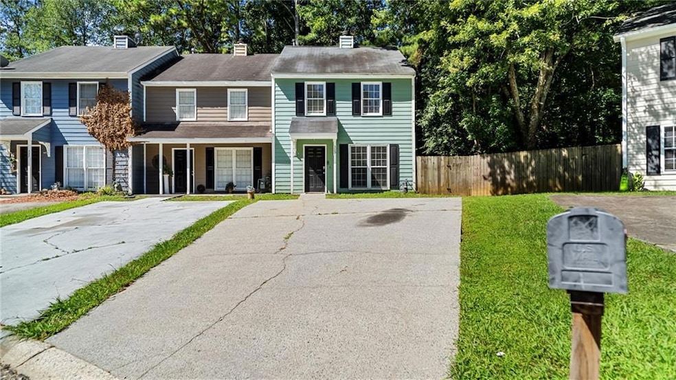 View of front of house featuring a chimney, a porch, driveway, and a shingled roof