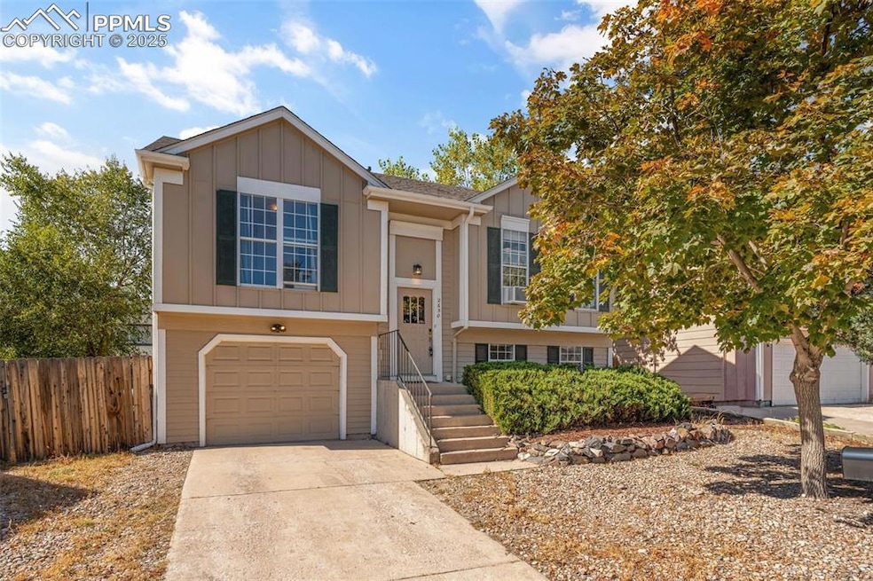 Split foyer home with board and batten siding, concrete driveway, and a garage