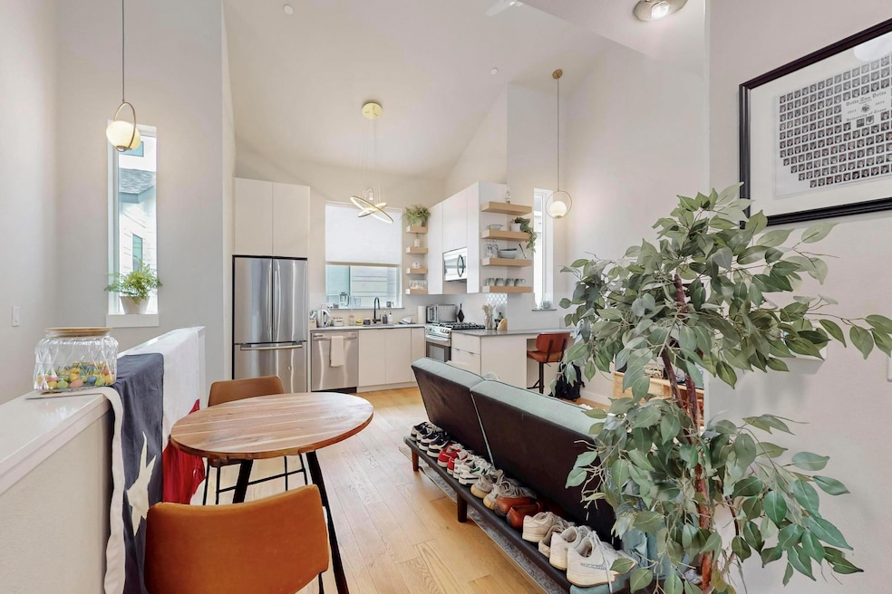 Dining area with high vaulted ceiling and light w
