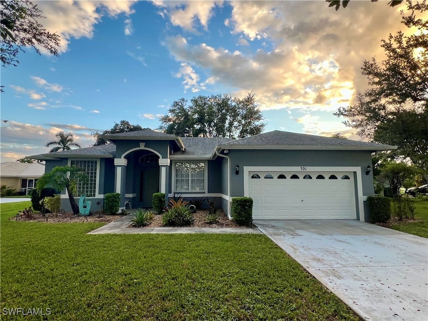 Ranch-style house with stucco siding, concrete driveway, an attached garage, and a front lawn