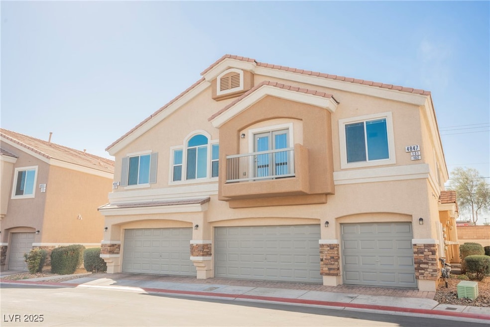 View of front of home with a garage, stone siding,