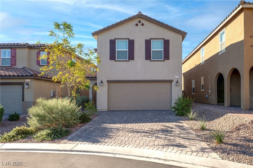 Mediterranean / spanish home with stucco siding, a garage, and decorative driveway