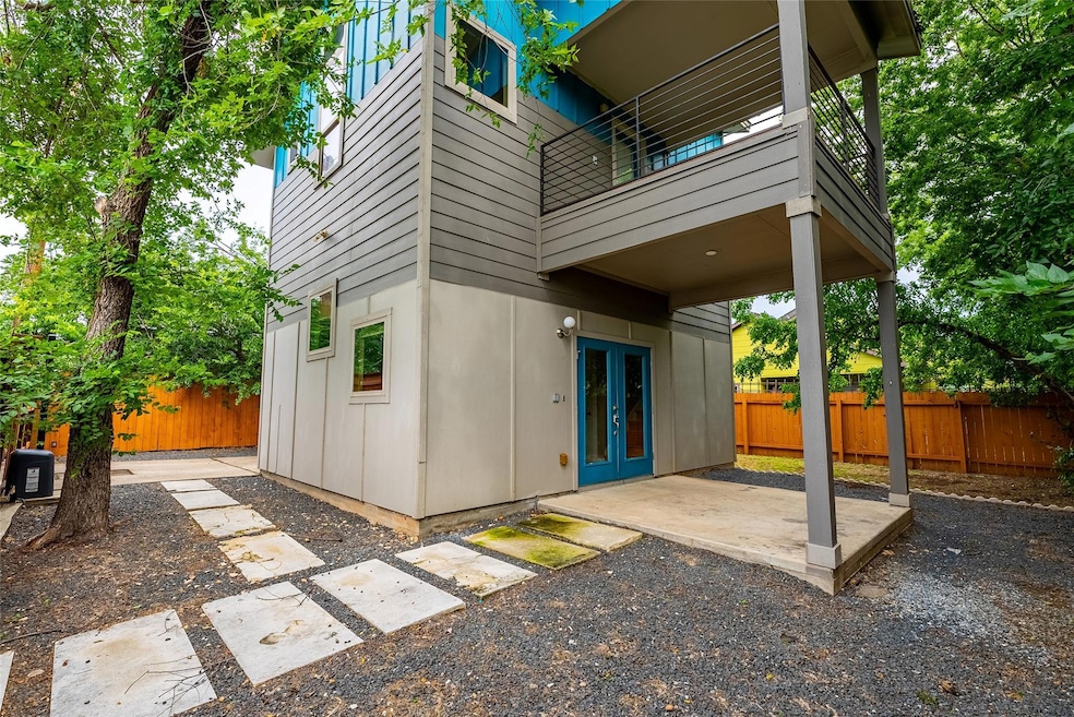 Back of property with french doors, a balcony, an